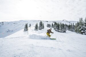 Man skiing down a snowy mountain in Vail