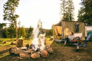 Woman camping next to a camp fire