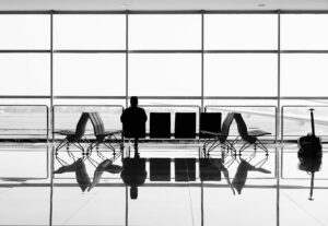 Silhouette of a man sitting in the airport at gate