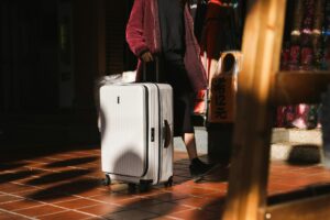 person rolling beige luggage