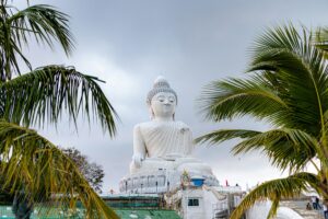 Big buddha statue surrounded by palm trees in Phuket