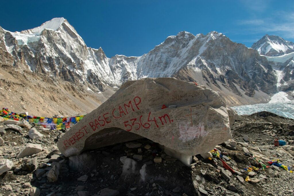 Rock displaying the words "Everest Base Camp" with mountains in background