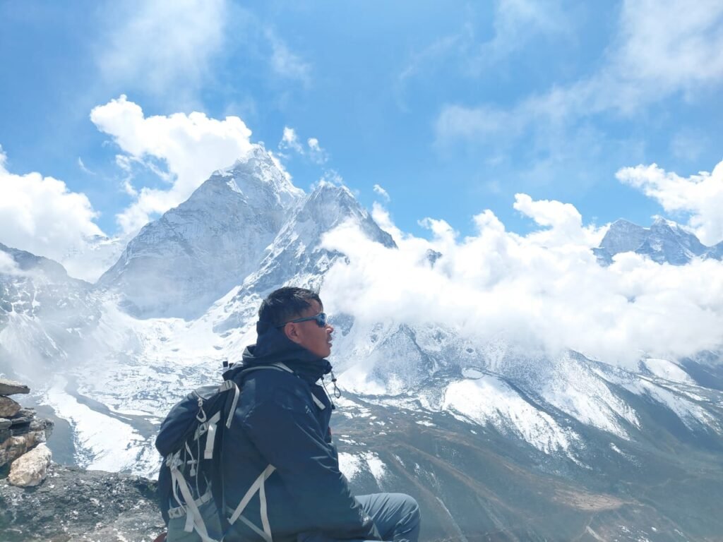 A man sitting in front of a snowy mountain
